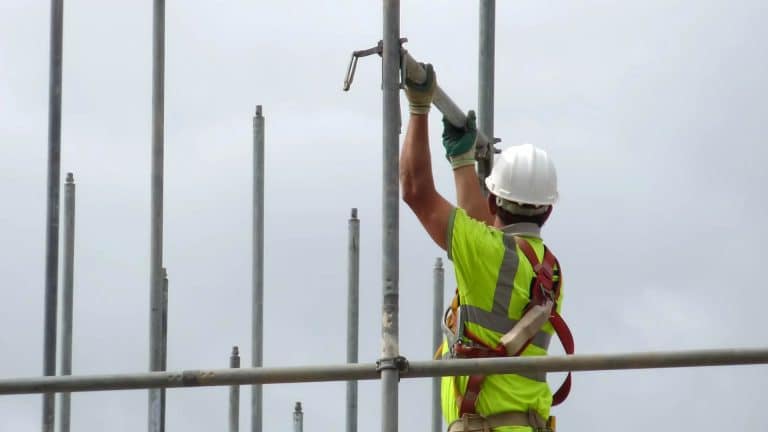 A man is setting up scaffolding after completing Scaffolding and Tower Training (PASMA).