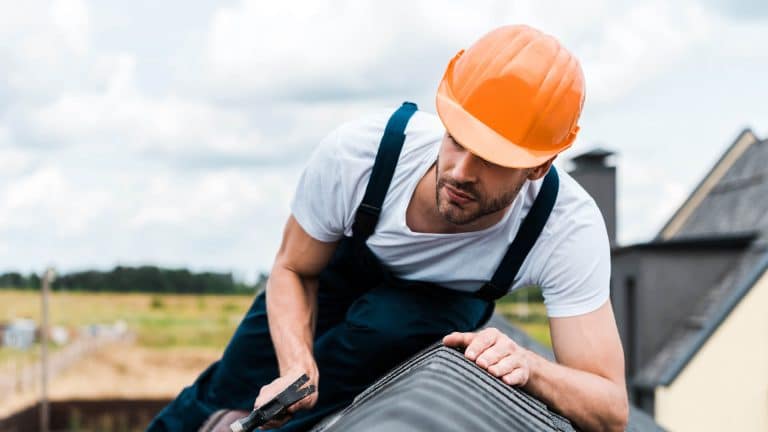 A man confidently stands on a roof because he completed the Safe Working at Height Course.