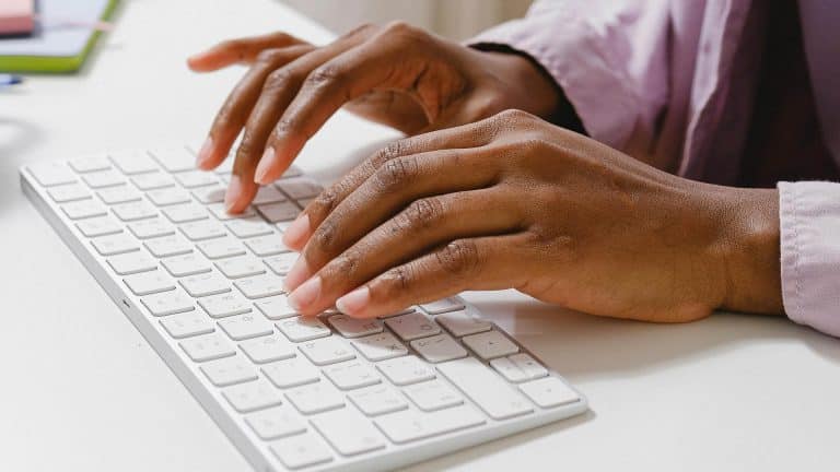 Hands typing on a laptop keyboard during the City & Guilds 2382-22 18th On-line Training Package.